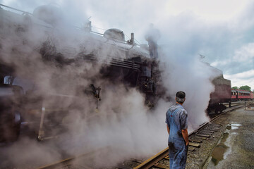 View of An Antique Steam Locomotive Warming Up Blowing Steam and Lots of Smoke on an Early Spring Morning