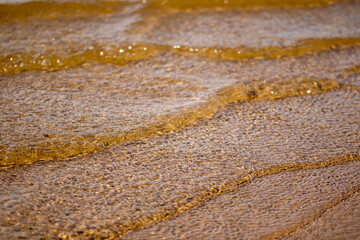 Fototapeta na wymiar Ripples in the water. sandy bottom of the river. Waves on the sandy shore