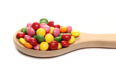 Sour colorful candies with five different fruit flavors in wooden spoon isolated on white background 