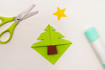 Step-by-step instructions for making Christmas Tree Corner Bookmarks. DIY. Creative origami ideas for kids. Top view, flat lay. Step 5 - cut the Christmas tree shape