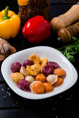 boiled dumplings assorted, different colors ravioli on wooden table