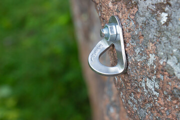 Close-up of reusable rock climbing bolt on rock face. Climbing equipment designed to organize belay...