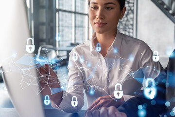 Businessman and businesswoman working together to protect clients confidential information and cyber security. IT hologram padlock icons over office background with panoramic windows.