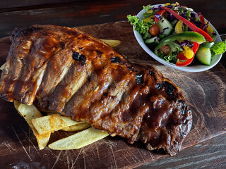 Beautifully prepared and tasty ribs with a side salad, chips