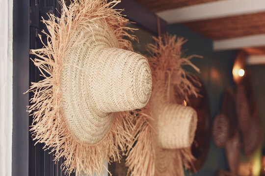 Fototapeta Handmade straw hats hanging in the store