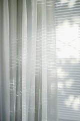 Sheer white organza curtain on the window, letting in sunlight.