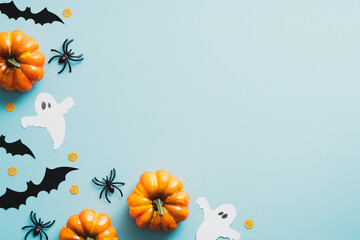 Happy halloween flat lay composition with ghosts, bats, spiders, orange pumpkins on blue...