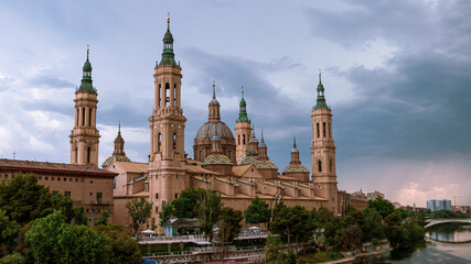 Fototapeta na wymiar Cityscape view on the roofs and spires of basilica of Our Lady in Zaragoza city.