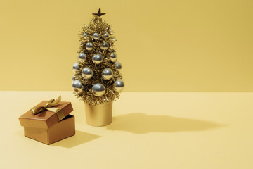 Christmas composition. Christmas tree gift and balls on a yellow background.