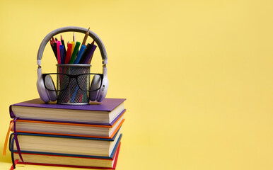 Back to school concepts. Teachers Day. Composition from a stack of colorful books pencils glasses...