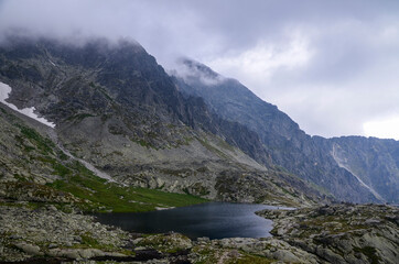 Beautiful scenery view of a mountain lake and rocks under cloudy sky in High Tatras National Park, Slovakia