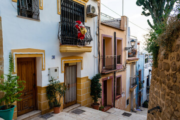 typical landscape of the old town of the city of alicante on a summer afternoon with white houses and yellow tones.  
