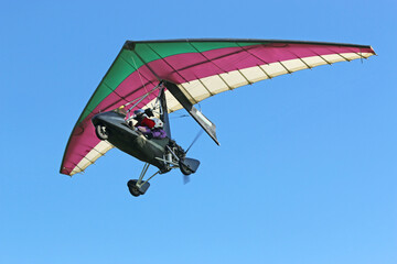 	
Ultralight airplane flying in a blue sky	
