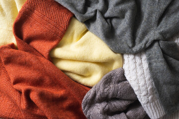 Fototapeta na wymiar Autumn or winter background with warm sweaters. Pile of knitted clothes.