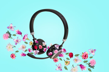 Creative composition made of headphones and different types of colorful flowers that come out of...