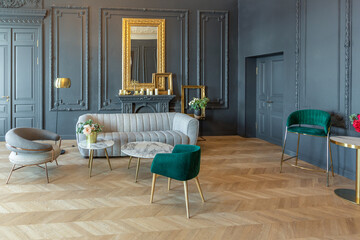 chic interior of the room in the Renaissance style of the 19th century with modern luxury furniture. walls of noble dark color are decorated with stucco and gilded frames, wooden parquet.