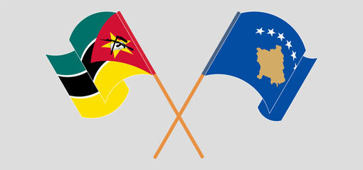Crossed and waving flags of Mozambique and Kosovo
