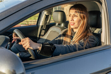 Latin blonde woman driving a car.