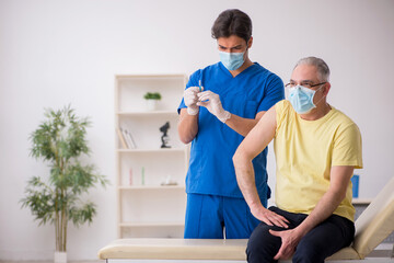 Old male patient visting young male doctor in vaccination concep