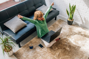 woman at home with laptop happy celebrating success