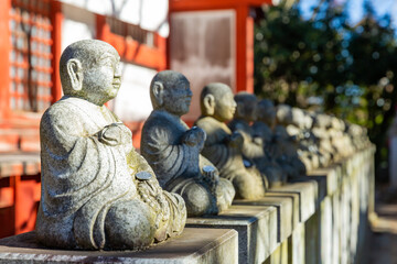 lining up stone Buddhism statue in silence in the temple of takao mountain on january first, tokyo, japan
