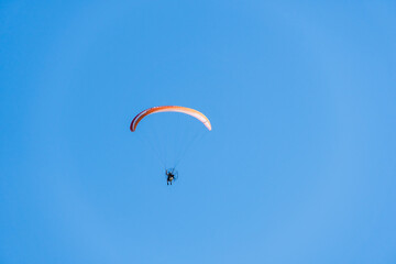 Paraglider flying over Saquarema beach, Rio de Janeiro. Sunny day with blue sky in the background
