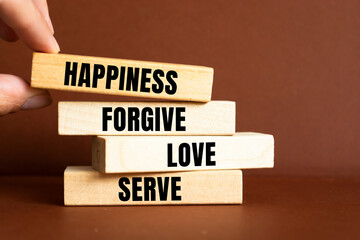 Inspirational single kind word on wooden blocks about happiness, forgive, love and serve.