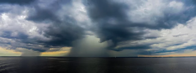 Fototapeten Dramatic dark seascape, panoramic view. Storm clouds and rain over the sea, cloudy weather, shower, storm © ANGHI