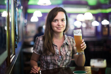 Portrait of sexy girl sits in bar with beer glass