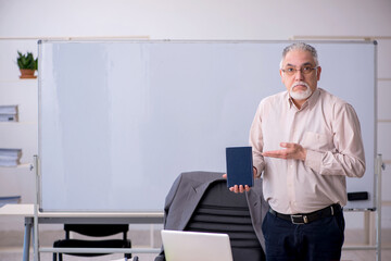 Naklejka na ściany i meble Old male teacher in front of whiteboard