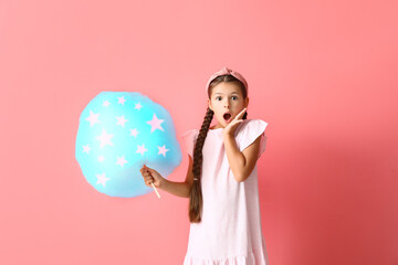 Surprised little girl with cotton candy on color background