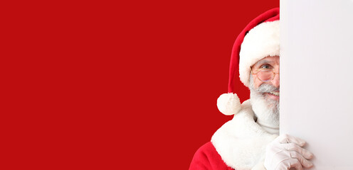 Happy Santa Claus with blank poster on color background with space for text