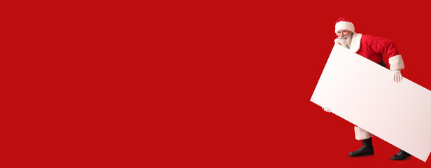 Santa Claus with blank poster on color background with space for text
