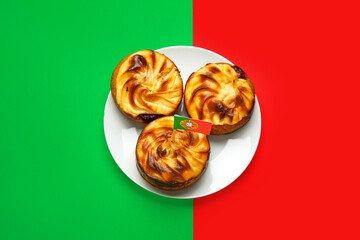Plate with traditional Portuguese dessert on color background