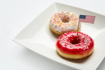 Plate with sweet donuts and USA flag on white background