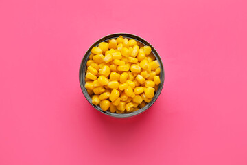 Opened tin can of corn kernels on color background