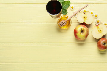 Honey with apples and sacramental goblet of wine on color wooden background. Rosh hashanah (Jewish New Year) celebration