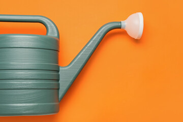 Watering can on color background