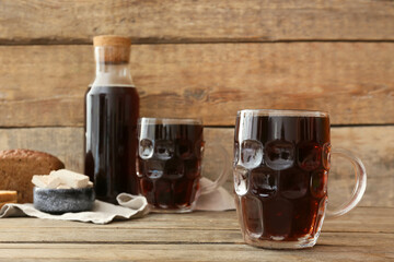 Mug of fresh kvass on wooden background