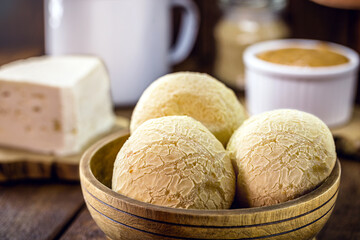 pot of Brazilian cheese bread, with cheese in the background and hot coffee