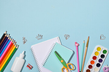 Background with stationery at the bottom on a blue background with a space for text. Back to school.