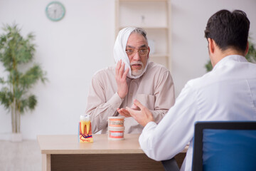 Old male patient visiting young male doctor dentist