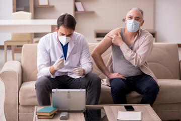 Young male doctor visiting old patient in vaccination concept