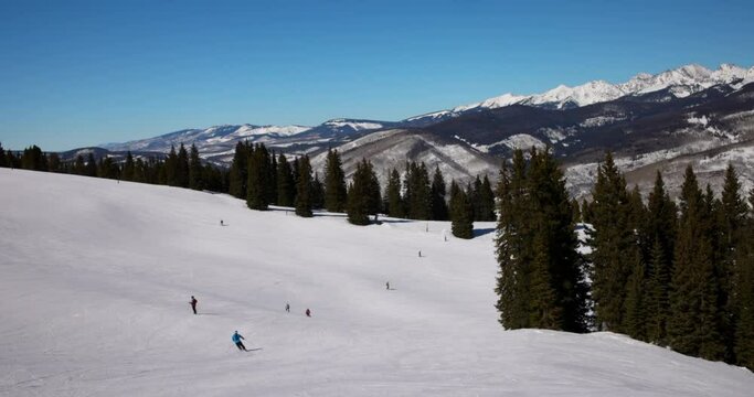 Panning Scenic View Of People Skiing Over Snow Covered Mountain On Sunny Day During Getaway Vacation - Vail, Colorado