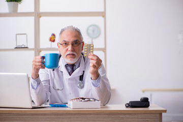 Old male doctor working in the clinic