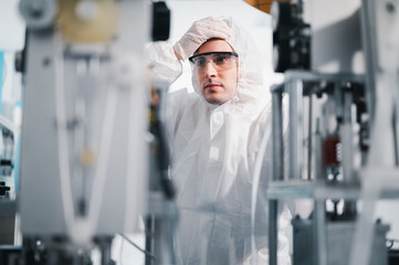 Fototapeta na wymiar Scientists wearing protective clothing Inspect mask making machines in a laboratory at an industrial plant. Anti-virus production warehouse. concept of safety and prevention coronavirus covid-19.
