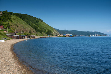 Baikal Lake in summer day. Focus on clear transparent water and coastal stones. Summer travel.