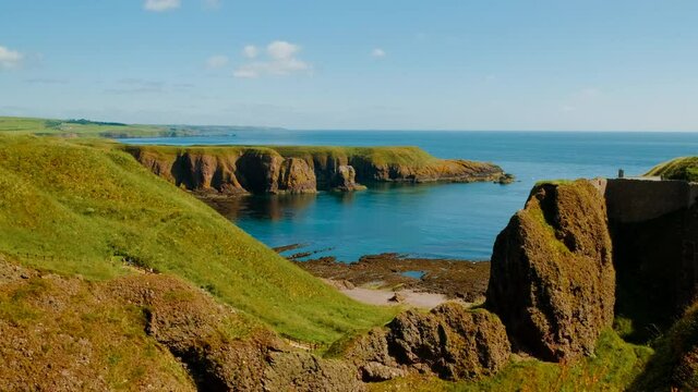Walking along the stunning northeastern coast of Scotland, featuring the Dunnottar Castle, a medieval fortress dating to 1400