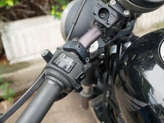 light switch button on a motorcycle handlebar.