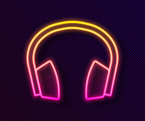 Glowing neon line Noise canceling headphones icon isolated on black background. Headphones for ear protection from noise. Vector